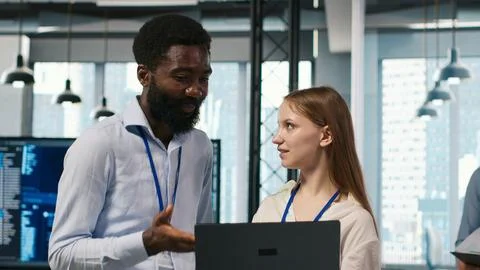 Female engineer and coworker coding AI algorithms to debug software issues Foto stock