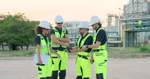 Female engineer and multiracial refinery technician review tablet data with Stock Footage 335605691
