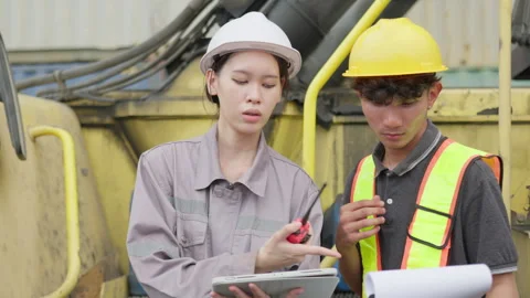 Female engineer and a technician collaborating on an industrial site Stock Footage 338295268