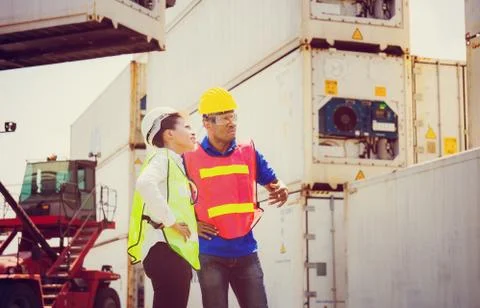 Female engineer checking containers box with worker man from cargo Fotos Stock