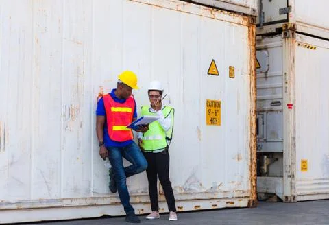 Female engineer checking containers box with worker man from cargo Stockfoto's