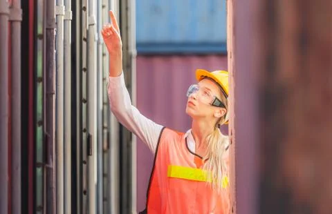 Female engineer checking containers box with from cargo container Stockfoto's