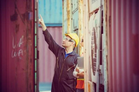 Female engineer checking containers box with worker man from cargo Stockfoto's