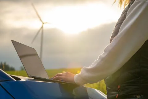 Female engineer checking the stability work of windmill in the field at sunlight Stock Photos