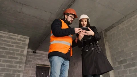 Female engineer communicates with the builder discussing the working moments of Video stock 123605637