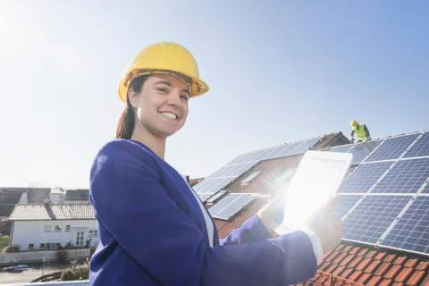 Female engineer controlling installation of solar panels Stock Photos