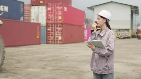 Female engineer coordinates logistics at a container yard Stock Footage 338295192