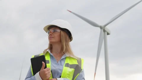 A female engineer with a digital tablet analyzes data from wind energy Stock Footage 270990211
