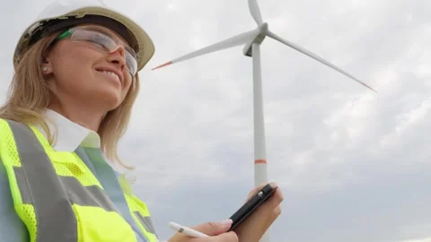 A female engineer with a digital tablet develops wind farm projects aimed at 스톡 동영상 276312463