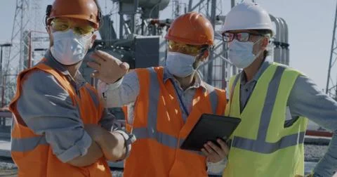 Female engineer discussing data on tablet with men Stock Photos