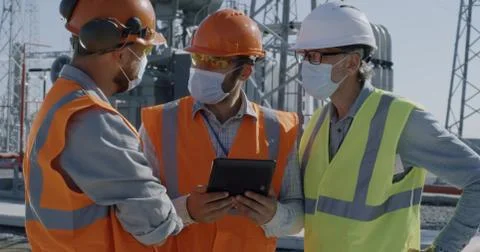 Female engineer discussing data on tablet with men Stock Photos