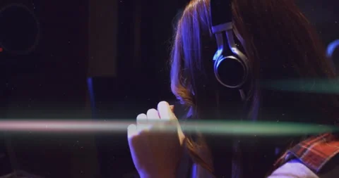 Female engineer entering studio and adjusting faders then securing headphones Vídeos de archivo 312904758