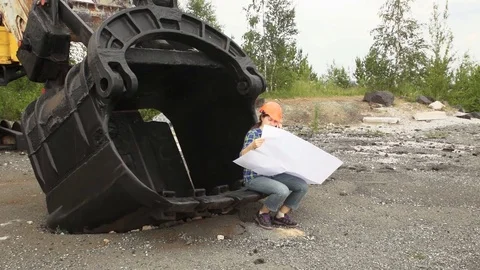 Female engineer examines a scheme sitting in a large bucket of a excavator. Stock Footage 80788633
