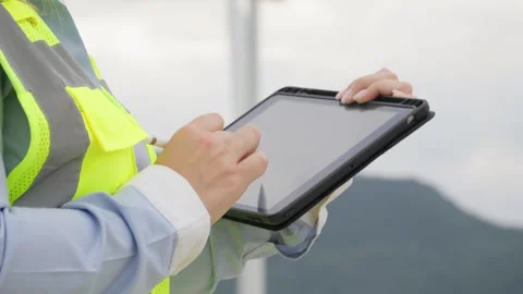 A female engineer examines wind energy usage data on a digital tablet Stock Footage 272632913