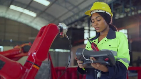 Female engineer examining and controlling robot arm at factory. Stock Footage 228860281