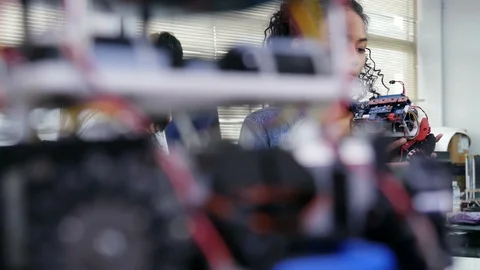 Female engineer fixing robot in workshop. Stock Footage 94736716