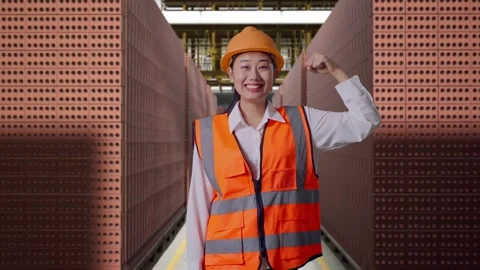 Female Engineer Flexing Her Bicep And Smiling With Brick In Stacks Stock Footage 303761708
