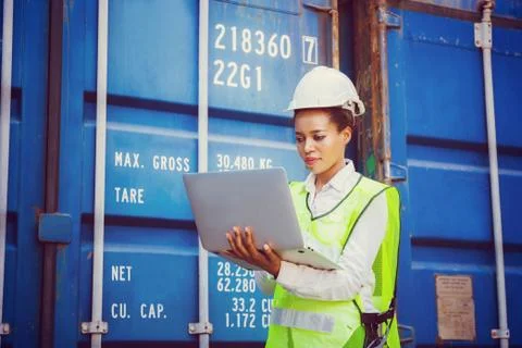 Female engineer in hardhat control loading containers box from cargo Photos