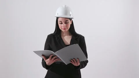 Female Engineer in Hardhat Reading Documents in Folder Stock Footage 345538670
