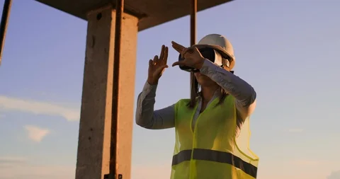 Female engineer in hardhat with VR glasses designing construction project at Stock Footage 113050416