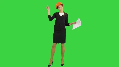 Female engineer in helmet holding papers and doing funny dance on a Green Screen Stock Footage
