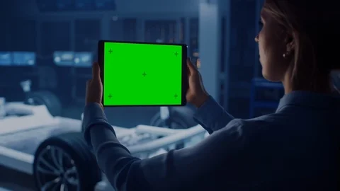 Female Engineer Holds a Tablet Computer with Green Screen Mock Up and Looks Stock Footage 105726173