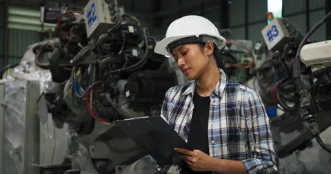 Female engineer inspecting robotic systems with clipboard in factory Stock-Footage 295608896