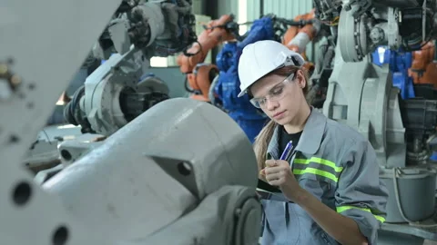 A female engineer installs a program on a robotics arm Stock Footage 241102171