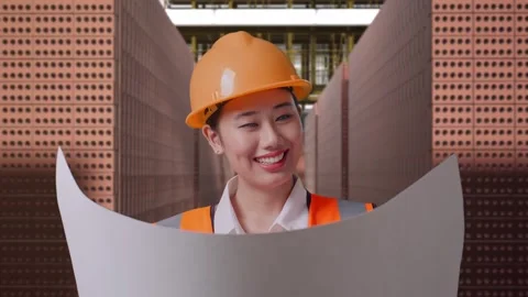 Female Engineer Looking At Blueprint In Her Hands With Brick In Stacks Stock Footage 303762546