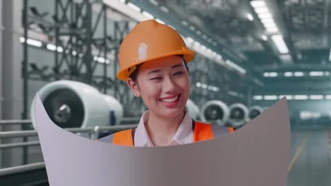 Female Engineer Looking At Blueprint In Her Hands, Aircraft Engine Factory Stock Footage 314608638