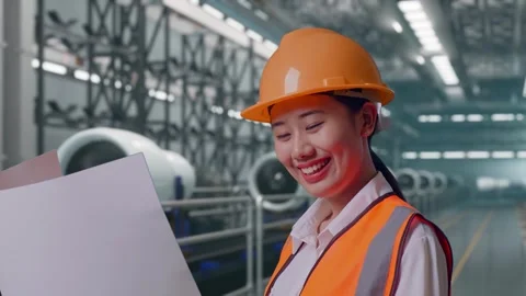 Female Engineer Looking At Blueprint In Her Hands, Aircraft Engine Factory Stock Footage 314608817