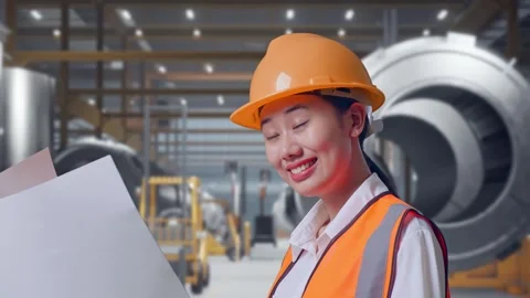 Female Engineer Looking At Blueprint In Her Hands at Heavy Factory Stock Footage 340825454