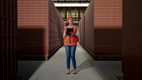 Female Engineer Looking At The Tablet In Her Hand With Brick In Stacks Stock Footage 303763270
