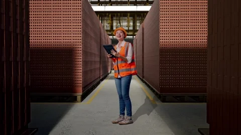 Female Engineer Looking At The Tablet In Her Hand With Brick In Stacks Stock Footage 303763422