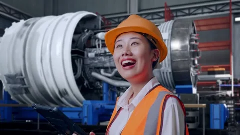 Female Engineer Looking At The Tablet In Her Hand With Jet Engine Stock Footage 306605367