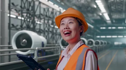 Female Engineer Looking At The Tablet In Her Hand, Aircraft Engine Factory Video stock 314608754