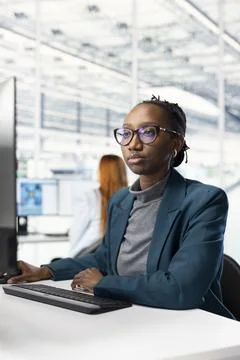 Female engineer models integrated circuit systems at workstation in RD facility Stock Photos