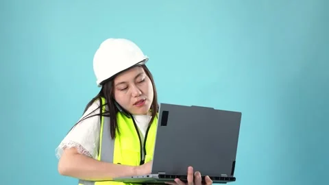Female Engineer Multitasking on Phone and Laptop against Blue Studio Backgrou Stock Footage 346556568