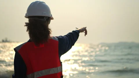 Female engineer at an oil refinery pointing direction Stockbeeldmateriaal 340080480
