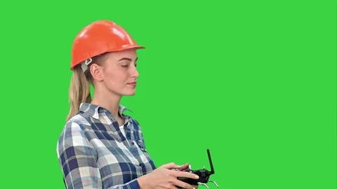 Female engineer operating a drone analyzing object on a Green Screen, Chroma Key Stock Footage 73875146