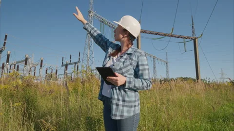 A female engineer at a power facility uses a tablet to take important measuremen Stock Footage 318383199