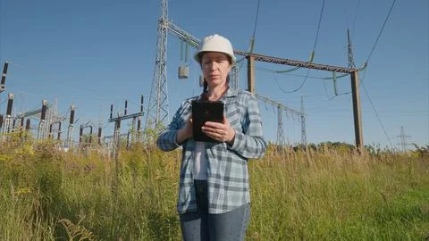 A female engineer at a power facility uses a tablet to take important measuremen Foto stock