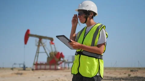 Female engineer records data at oil pump in desert heat 스톡 동영상 326802749