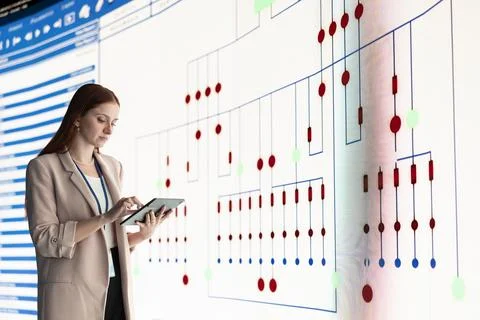 Female engineer reviews PCB layout using tablet Stock Photos