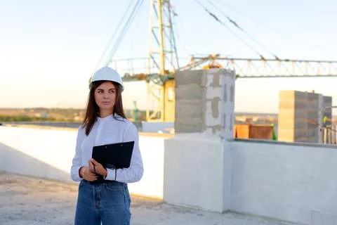 Female engineer showing a document to a construction worker on a rooftop Stock Photos