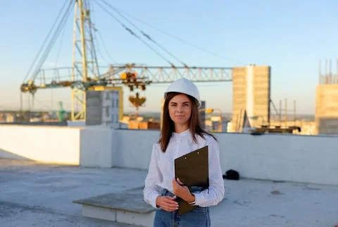 Female engineer showing a document to a construction worker on a rooftop Stock Photos