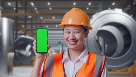Female Engineer Showing Green Screen Smartphone at Heavy Factory 動画素材 340825140