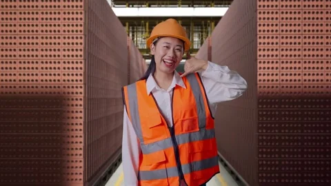 Female Engineer Smiling And Making Call Me Gesture With Brick In Stacks Stock Footage 303761616