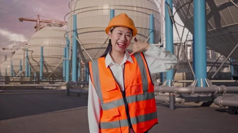 Female Engineer Smiling And Making Call Me Gesture with Spherical Tank Stock Footage 335068277