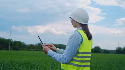 A female engineer stops on the road in front of a high voltage power line, takes 스톡 동영상 241801660